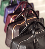 a row of four suitcases with a variety of different colors