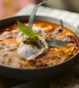 a bowl of soup with a fork and a fork