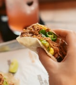a person holding a sandwich sandwich on a plate