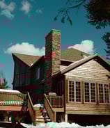 a house with a wooden deck and tall chimney