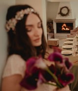 a woman in a white dress is holding a bouquet