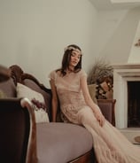 a woman in a long dress sitting on a couch