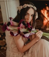 a woman in a dress with flowers in her hands