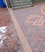 a brick path and concrete steps leading to a house