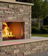 a stone fireplace with a fire burning