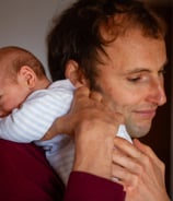 a man holding a baby in his arms