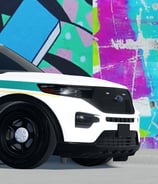 a police car parked in front of a wall with graffiti