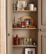 a cabinet with a shelf full of bottles and bottles