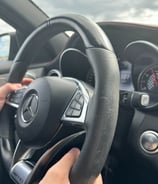 a person holding a steering wheel in a car