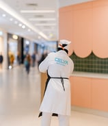 Femme de ménage utilisant une balayette pour nettoyer le sol dans un centre commercial à Casablanca