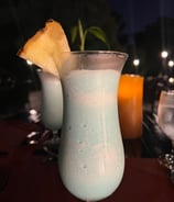 product photography of a drink in a glass with a pineapple on top