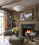 a living room with a fireplace and chairs