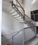 a staircase with a metal railing and a metal railing