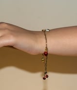 a woman's hand holding a bracelet with a chain link bracelet