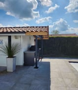 Structure métallique sur mesure pour cuisine extérieure avec auvent en tuiles, conçue par un métallier ferronnier à proximité