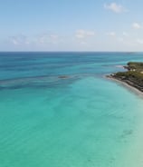 a boat is sailing in the ocean near a beach