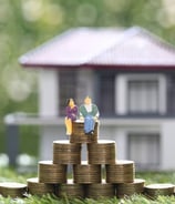 a couple of people sitting on top of a pile of coins