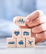 a person holding a wooden block with icons of people