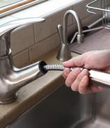 unscrewing the nut from the faucet for the replacement