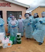 a group of people in protective clothing standing in front of a building