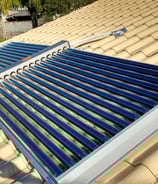 "Aquecedor solar de água instalado em telhado para uso residencial, utilizando energia solar térmica