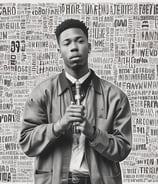 a rapper standing behind a microphone surrounded by words floating around him