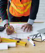 Consultor técnico elaborando documentação com ferramentas de engenharia