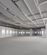 The image depicts the interior ceiling of a building under construction. There are wooden beams and a partial view of the roof structure. Two rectangular window installations are visible.