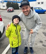 a man and a child standing in a parking lot