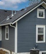 a house with a blue house with a black roof