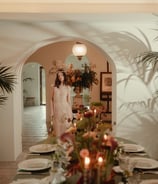 a woman standing in front of a table with a candle