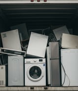 A box truck filled with old junk appliances.