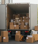 A box truck full of moving boxes and furniture.