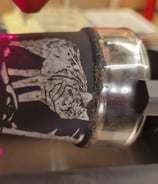 Ein kleine Trinkglas, schwarz angemalt und mit einem Wolf Motiv
