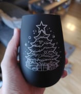 Schwarzes Glas, in der Hand gehalten, mit einem Weihnachtsbaum und Geschenke Motiv