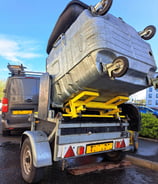 a trailer mounted bin cleaner with a commercial sized bin raised, ready for cleaning