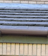 a close-up image of a roof with brown gutter.