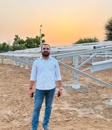 a man with a camera and a camera in front of a solar array