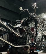 custom motorcycle parked on a lift inside of Schmidt Motos