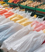 Paper bags with transparent windows are arranged on a wooden shelf, each labeled with product names such as Madeleine and Chestnuts, accompanied by price tags in both English and Chinese.