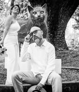Pareja de novios el dia de su boda, posando junto a una escultura