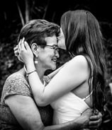 Novia el dia de su boda besando la frente de su madre