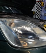 a car with a hood on it and a car in the background