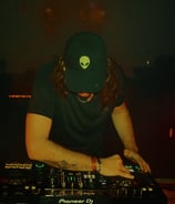 a man in a hat and a hat on a dj booth