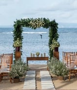 Beach wedding decoration with green drapes and tropical flowers by Pune wedding planning experts