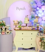 Colorful birthday party decoration with balloon arch, cake table, and LED lights by Pune party planner.