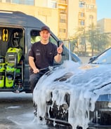 “Mobile detailing expert cleaning car interior with vacuum”
