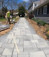 a paver project with grey paver stones being organized for a home walkway
