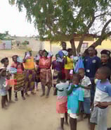 Umoja foundation : a group of people standing around a group of children