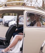 Elegant, Herts, Bride & Groom ready to depart after wedding ceromony in cream VW Beetle wedding car